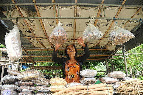 65 năm đường Trường Sơn - đường Hồ Chí Minh huyền thoại- Ảnh 4. Bà Ngô Thị Bốn, người dân vùng Bến Giằng (Quảng Nam), bán nông sản vùng cao trên đường Hồ Chí Minh. Con đường đã đổi thay số phận người dân vùng heo hút