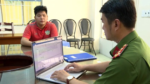 Thanh niên giả cảnh sát hình sự, cưỡng đoạt tiền ở Thủ Đức- Ảnh 1. Nguyễn Khoa Minh (áo cam) tại cơ quan công an - Ảnh: Công an cung cấp