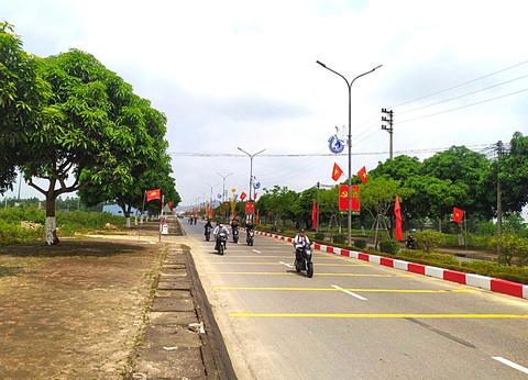 Đổi thay ở xã Tùng Ảnh, quê hương Trần Phú- Ảnh 2. Đường về xã Tùng Ảnh khang trang và rợp bóng cờ - Ảnh: L.MINH
