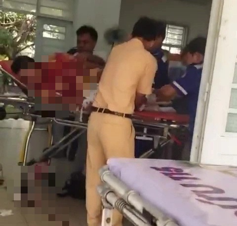 Xe CSGT huyện Cần Giờ va chạm xe máy khác, 3 người nguy kịch- Ảnh 3. Chiến sĩ cảnh sát giao thông được đưa vào trạm xá để sơ cứu, chảy nhiều máu - Ảnh cắt từ video