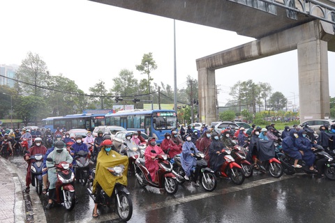 TP.HCM đang mưa dông nhiều nơi, người dân chú ý kẹt xe sáng đầu tuần- Ảnh 5. Nhiều người đứng dưới dạ cầu trú mưa khiến giao thông phía sau di chuyển chậm tại ngã tư Thủ Đức - Ảnh: NGỌC QUÝ
