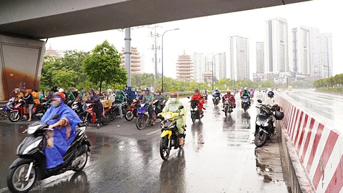 Trú mưa kiểu 'trời ơi đất hỡi'!- Ảnh 1. Người trú mưa chiếm hết nửa phần đường lưu thông dưới gầm cầu vượt Cát Lái (TP Thủ Đức)