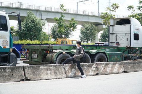 Leo dải phân cách băng qua đường, nhiều người đang đùa với 'tử thần'- Ảnh 3. Nam sinh băng qua xa lộ Hà Nội, giữa dòng xe container đang đổ dốc - Ảnh: XUÂN ĐOÀN