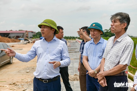 Đường vành đai 4 hơn 85.000 tỉ sau gần 1 năm khởi công giờ ra sao?- Ảnh 6. Bí thư Huyện ủy Mê Linh Nguyễn Thanh Liêm (bìa trái) đi kiểm tra tiến độ triển khai dự án đường vành đai 4 trên địa bàn huyện - Ảnh: NAM TRẦN