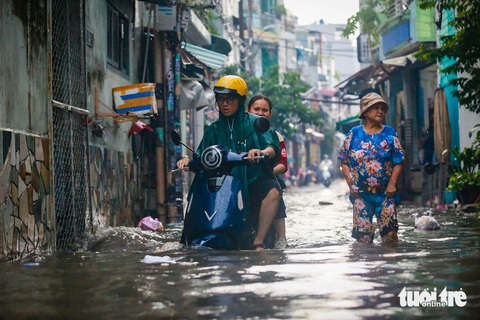 Người dân hô hoán nhau móc cống 'giải cứu' hẻm Chu Văn An ngập rác- Ảnh 5. Một số xe máy cố gắng chạy qua con hẻm này - Ảnh: CHÂU TUẤN