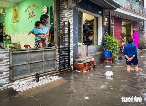Người dân hô hoán nhau móc cống 'giải cứu' hẻm Chu Văn An ngập rác- Ảnh 6. Người dân dùng tấm tôn để chắn nước vào nhà - Ảnh: CHÂU TUẤN