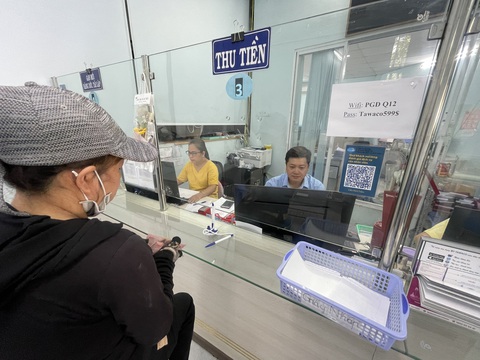 Ngành nước TP.HCM: Nhận diện khách hàng là trung tâm để phục vụ- Ảnh 2. Nhân viên Công ty cổ phần cấp nước Trung An giải quyết thủ tục cho người dân - Ảnh: DƯƠNG HÂN