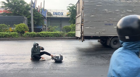Xe chở nước mắm chảy trên quốc lộ, người đi xe máy bị trượt ngã- Ảnh 3. Một thanh niên bị ngã vì đường trơn.