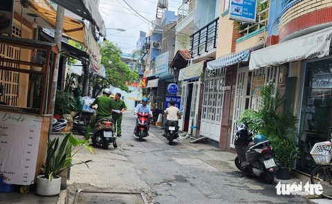 Tạt axit vào bàn nhậu khiến 1 người chết, 7 người bị thương- Ảnh 1. Lực lượng chức năng trích xuất camera, hỏi nhân chứng xung quanh hiện trường phục vụ công tác điều tra - Ảnh: MINH HÒA