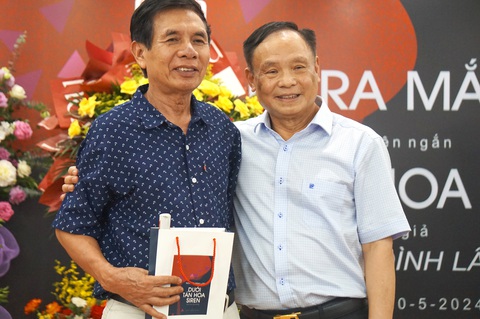 Dưới tán hoa siren: Cuộc 'mưu sinh vĩ đại' của người Việt trên đất Nga- Ảnh 1. Tác giả Nguyễn Đình Lâm (phải) chụp ảnh lưu niệm cùng độc giả trong buổi ra mắt sách - Ảnh: T.ĐIỂU