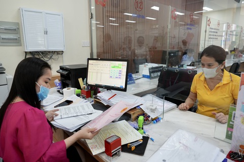 Yêu cầu bản sao chứng thực không quá 6 tháng: Việc lạc hậu nên bỏ đi- Ảnh 1. Cán bộ UBND quận Tân Phú, TP.HCM đóng dấu chứng thực các loại giấy tờ cho người dân - Ảnh: HỮU HẠNH