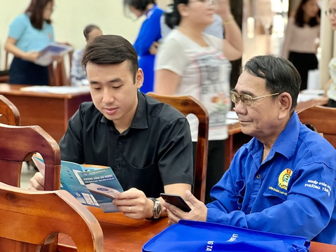 Lừa đảo giả danh bảo hiểm xã hội- Ảnh 1. Người lao động tìm hiểu các thông tin từ tờ rơi hướng dẫn sử dụng VssID - Bảo hiểm xã hội số tại một chương trình do Liên đoàn Lao động TP.HCM tổ chức - Ảnh: HUỲNH NHƯ