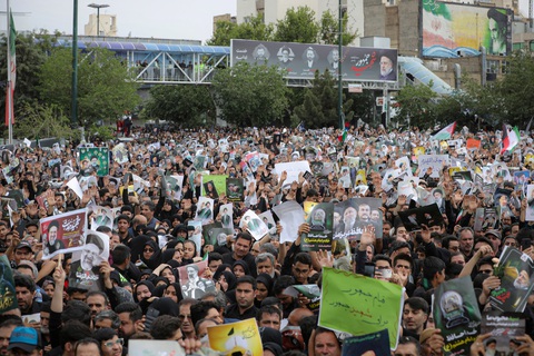 Người dân tiễn biệt cố tổng thống Iran trước lễ an táng- Ảnh 2. Người dân cầm theo vô số ảnh của cố Tổng thống Raisi trong ngày an táng - Ảnh: REUTERS