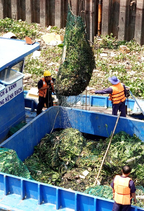 Chống ngập: Trước tiên phải bớt xả rác- Ảnh 1. Công ty TNHH MTV Dịch vụ công ích quận 8, TP.HCM vớt rác trên rạch Bến Nghé - Ảnh: T.T.D.