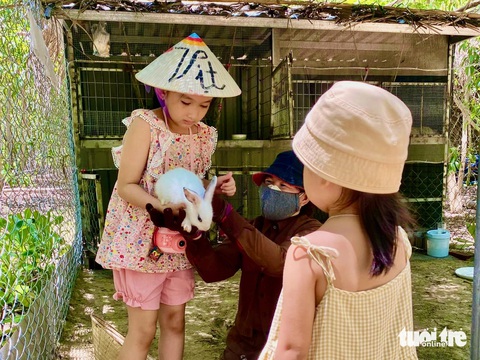 Khánh Hòa xây dựng du lịch xanh, khách làm nông dân ngay tại resort- Ảnh 1. Du khách nhỏ tuổi trải nghiệm chăm sóc vật nuôi - Ảnh: TUẤN ANH