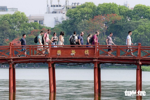 Bộ Chính trị: Phát triển trục sông Hồng để dòng sông thành biểu tượng mới của Hà Nội- Ảnh 1. Du khách đi qua cầu Thê Húc để vào đền Ngọc Sơn (quận Hoàn Kiếm) tham quan - Ảnh: NAM TRẦN