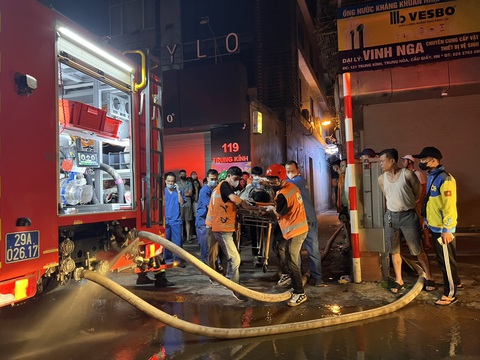 Từ vụ cháy nhà trọ 14 người chết: Chủ nhà, người thuê phòng cần làm gì để thoát nạn?- Ảnh 2. Lực lượng chức năng đưa các nạn nhân ra khỏi vụ cháy - Ảnh: MINH THANH
