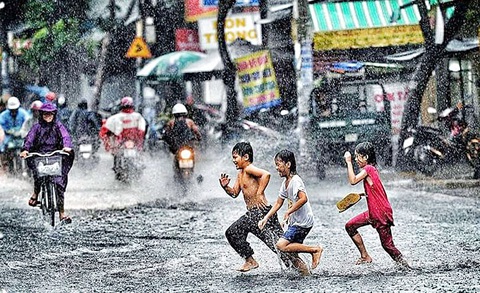 Trẻ em vui đùa tắm mưa trên đường - Ảnh: FLICKR Trẻ em vui đùa tắm mưa trên đường - Ảnh: FLICKR