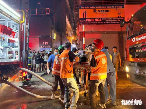 Vụ cháy nhà trọ làm 14 người chết: Còn 3 nạn nhân chưa nhận dạng được- Ảnh 1. Lực lượng chức năng đưa thi thể các nạn nhân ra ngoài - Ảnh: MINH THANH