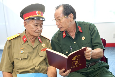 Ông Trần Văn Bản (phải) cùng ôn lại kỷ niệm lưu giữ trong kỷ vật của các đồng đội - Ảnh: Nguyễn Hữu Hạnh Ông Trần Văn Bản (phải) cùng ôn lại kỷ niệm lưu giữ trong kỷ vật của các đồng đội - Ảnh: NGUYỄN HỮU HẠNH