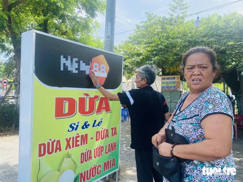 Quảng bá web cờ bạc tràn lan khắp hàng quán ở Đà Nẵng- Ảnh 1. Bà Tý khi được biết logo in trên bảng hiệu mà mình được tặng là của một trang web cờ bạc, đã dán giấy che lại, nhưng vẫn