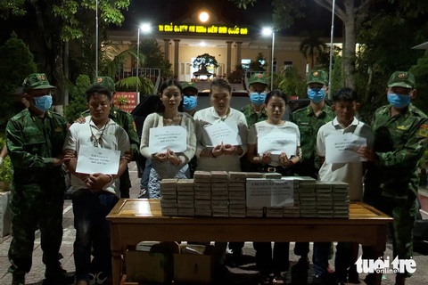Nhóm có 2 sinh viên Lào chở 100 bánh heroin vào Việt Nam- Ảnh 1. Nhóm 5 người Lào và tang vật 100 bánh heroin - Ảnh: PHƯỚC TRUNG