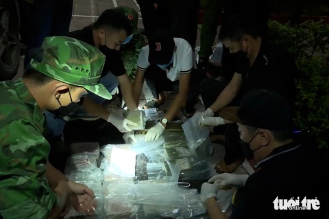 Nhóm có 2 sinh viên Lào chở 100 bánh heroin vào Việt Nam- Ảnh 2. Lực lượng đánh án kiểm đếm tang vật - Ảnh: PHƯỚC TRUNG