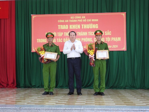 4 đơn vị công an phá nhanh vụ giết người giấu xác trong vali được khen thưởng- Ảnh 3. Ông Trương Tiến Triển - phó chủ tịch UBND huyện Cần Giờ - trao thưởng cho Đội cảnh sát hình sự và Công an xã Bình Khánh, thuộc Công an huyện Cần Giờ - Ảnh: Công an TP.HCM