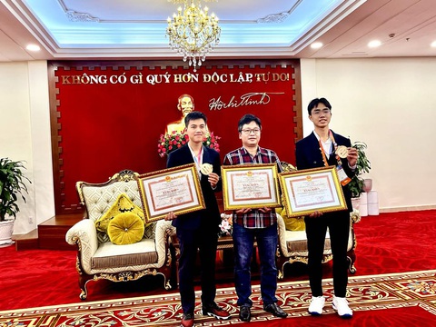 Người đứng sau giải bạc cuộc thi khoa học kỹ thuật quốc tế quý như vàng- Ảnh 3. Thầy Đỗ Quốc Anh Triết cùng 2 học trò nhận bằng khen của UBND TP.HCM trong lễ đón tại sân bay Tân Sơn Nhất - Ảnh: MỸ DUNG