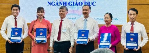 TP.HCM bổ nhiệm hiệu trưởng hai trường Trần Đại Nghĩa- Ảnh 1. Ông Nguyễn Minh (bìa phải) và bà Trần Thị Hồng Thủy (thứ hai từ phải sang) nhận quyết định bổ nhiệm hiệu trưởng chiều 27-5 - Ảnh: P.T.Y