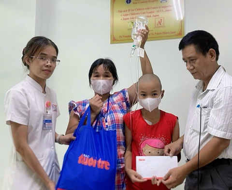 Nhận món quà từ Ước mơ của Thúy, mẹ ôm con mừng run vì ‘có tiền vào thuốc’- Ảnh 2. Đại diện báo Tuổi Trẻ (bìa phải) trao quà cho bệnh nhi ung thư tại Trung tâm nhi khoa - Bệnh viện Trung ương Huế - Ảnh: BẢO PHÚ