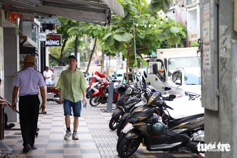 Nhiều địa phương chậm đề xuất tuyến đường đủ điều kiện thu phí lòng đường, vỉa hè- Ảnh 1. Đến nay, nhiều đường ở quận 1 đã được kẻ vạch vàng để thực hiện thu phí sử dụng tạm lòng đường, vỉa hè. Xe máy xếp gọn gàng trong vạch kẻ trên đường Nguyễn Trãi, đảm bảo lối đi bộ cho người dân - Ảnh: NGỌC QUÝ