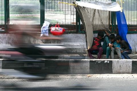 Nhiệt độ tại Ấn Độ vượt 50 độ C, gần nóng nhất mọi thời đại- Ảnh 5. Trẻ em tại thủ đô New Delhi, Ấn Độ tránh nóng bên đường ngày 28-5 - Ảnh: AFP