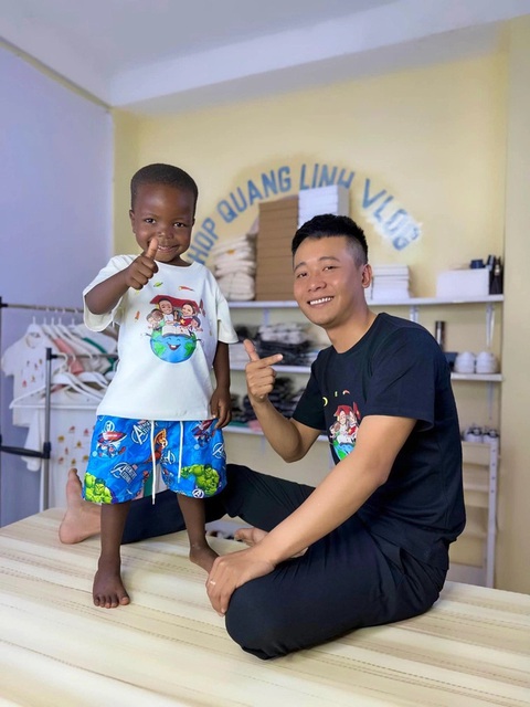 Lôi Con, cậu bé châu Phi nói giọng Nghệ An hát nhạc Việt, là ai?- Ảnh 3. Cậu bé Lôi Con cùng cha nuôi Quang Linh Vlog, hai cha con có cơ duyên gặp gỡ từ hơn 2 năm trước và gắn bó đến giờ - Ảnh: NVCC