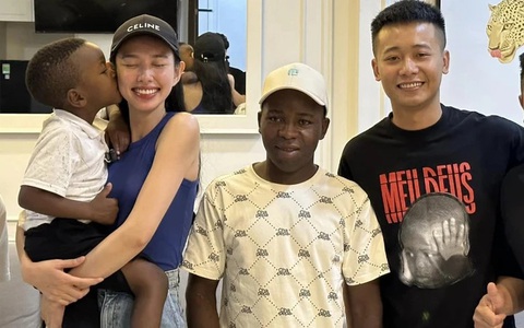 Lôi Con, cậu bé châu Phi nói giọng Nghệ An hát nhạc Việt, là ai?- Ảnh 2. Lôi Con chụp ảnh cùng hoa hậu Thùy Tiên và hai người cha của mình - Ảnh: NVCC