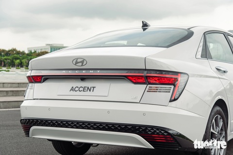 Chi tiết Hyundai Accent 2024 giá cao nhất 569 triệu đồng: Lột xác toàn diện trước Vios, City- Ảnh 7. Hyundai Accent 2024 có phần đuôi hơi vuốt xuống kiểu Fastback, trông trở nên thể thao và trẻ trung hơn. Cụm đèn hậu LED kéo dài sang hai bên dạng chữ H. Cản sau có 4 cảm biến và camera lùi. Cốp xe vẫn chỉ đóng/mở cơ, nhưng tích hợp tính năng mở cốp rảnh tay (Smart trunk) rất hữu dụng khi xách đồ.