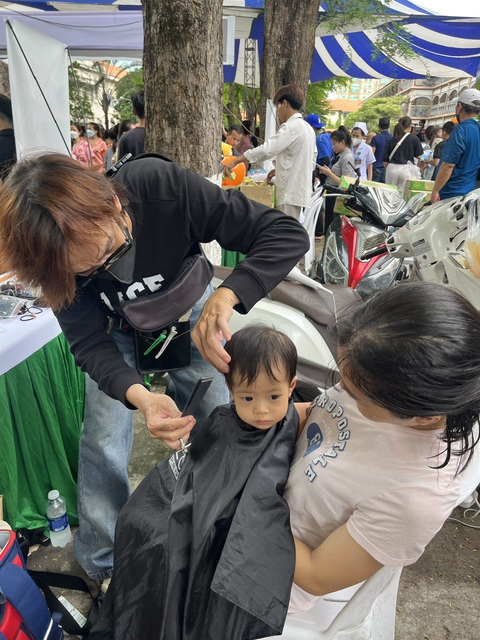 Bệnh nhi được cắt tóc, chụp hình, xem ảo thuật... tại 'Ngày hội tuổi thơ'- Ảnh 2. Một bệnh nhi mắc bệnh viêm phổi đang được cắt tóc - Ảnh: THÙY DƯƠNG
