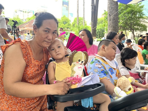 Bệnh nhi được cắt tóc, chụp hình, xem ảo thuật... tại 'Ngày hội tuổi thơ'- Ảnh 3. Bệnh nhi mắc bệnh nặng không đi được, không nói được nhưng vẫn thích dõi theo chương trình trên sân khấu - Ảnh: THÙY DƯƠNG