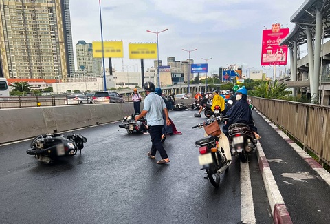 Xe máy trượt té, tông nhau trên cầu Sài Gòn sau cơn mưa giải nhiệt- Ảnh 1. Hàng chục xe máy tông nhau liên hoàn trên cầu Sài Gòn (hướng TP Thủ Đức đi quận Bình Thạnh) sáng 4-5 - Ảnh: Maria Phạm
