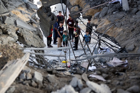 Những người Palestine bên cạnh hiện trường một vụ tấn công của Israel tại Dải Gaza hôm 3-5 - Ảnh: AFP Những người Palestine bên cạnh hiện trường một vụ tấn công của Israel tại Dải Gaza hôm 3-5 - Ảnh: AFP
