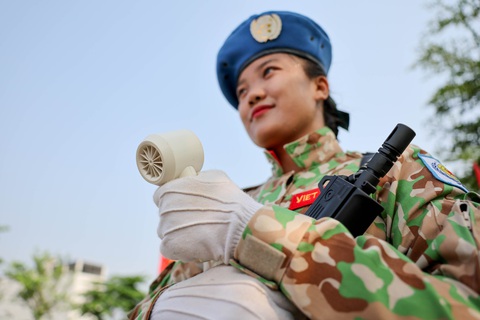 Những Tranh thủ giờ nghỉ giải lao, chiến sĩ Phạm Thùy Dương dùng một chiếc quạt nhỏ để làm mát cơ thể - Ảnh: NGUYỄN KHÁNH