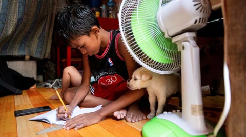Nhiều nước châu Á tiếp tục đóng cửa trường học vì nắng nóng- Ảnh 3. Một học sinh tại thủ đô Manila, Philippines đang học bài tại nhà ngày 26-4 sau thông báo đóng cửa trường học vì nắng nóng - Ảnh: REUTERS