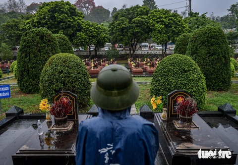 Dòng người đội mưa đến viếng Nghĩa trang liệt sĩ quốc gia A1- Ảnh 1. Lặng yên đứng thắp hương tưởng nhớ giữa những hàng mộ thẳng tắp ở Nghĩa trang liệt sĩ quốc gia A1 - Ảnh: NAM TRẦN