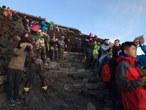 Trekking núi Phú Sĩ, ngắm mặt trời mọc lên từ biển mây- Ảnh 1. Du khách chụp cảnh bình minh trên đỉnh núi Phú Sĩ - Ảnh: NhatbanAZ