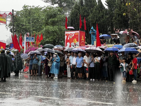 Người dân cầm cờ ngồi chờ khắp các ngả đường TP Điện Biên Phủ chờ đoàn diễu binh, diễu hành đi qua - Ảnh: NAM TRẦN Người dân đội mưa chờ đoàn diễu binh, diễu hành đi qua - Ảnh: NAM TRẦN