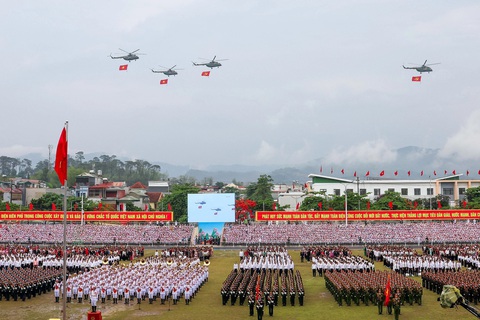 Hùng tráng lễ diễu binh, diễu hành kỷ niệm 70 năm Chiến thắng Điện Biên Phủ- Ảnh 1. Biên đội trực thăng vũ trang thuộc Quân chủng Phòng không - Không quân, Quân đội nhân dân Việt Nam mang theo cờ Đảng, cờ Tổ quốc bay ngang qua sân vận động tỉnh Điện Biên - Ảnh: NGUYỄN KHÁNH