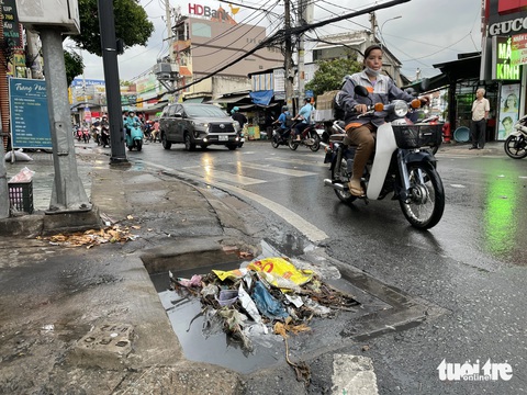 TP.HCM mưa dông khắp nơi, cuối cùng nhiều nơi cũng mưa lớn- Ảnh 3. Từng mảng rác trôi chặn cứng miệng cống thoát nước - Ảnh: CHÂU TUẤN