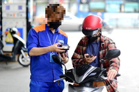 Từ vụ xin mật khẩu WiFi chỗ bán xăng: Muốn không tiền mặt, phải luôn online- Ảnh 1. Người dùng thanh toán không tiền mặt tại một cây xăng - Ảnh: QUANG ĐỊNH