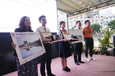 Trao giải hội thi sáng tác ảnh Tuổi Xanh 2024- Ảnh 1. Phó giám đốc Sở GD-ĐT Nguyễn Bảo Quốc và Phó tổng thư ký tòa soạn báo Tuổi Trẻ Trương Bảo Châu trao giải nhất cho 2 thí sinh bảng THCS và THPT (ở giữa) - Ảnh: NGUYỄN CÔNG THÀNH