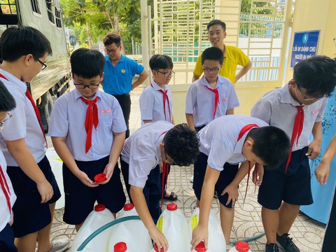 Học sinh, giáo viên TP.HCM chung tay mang nước ngọt về miền Tây- Ảnh 5. Học sinh bơm nước để thầy cô chở xuống cho bà con miền Tây - Ảnh: NNCC
